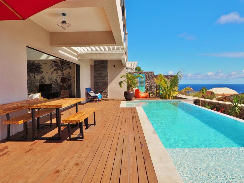 Villa Éden Roc au coucher du soleil avec piscine à débordement face à l'océan Indien